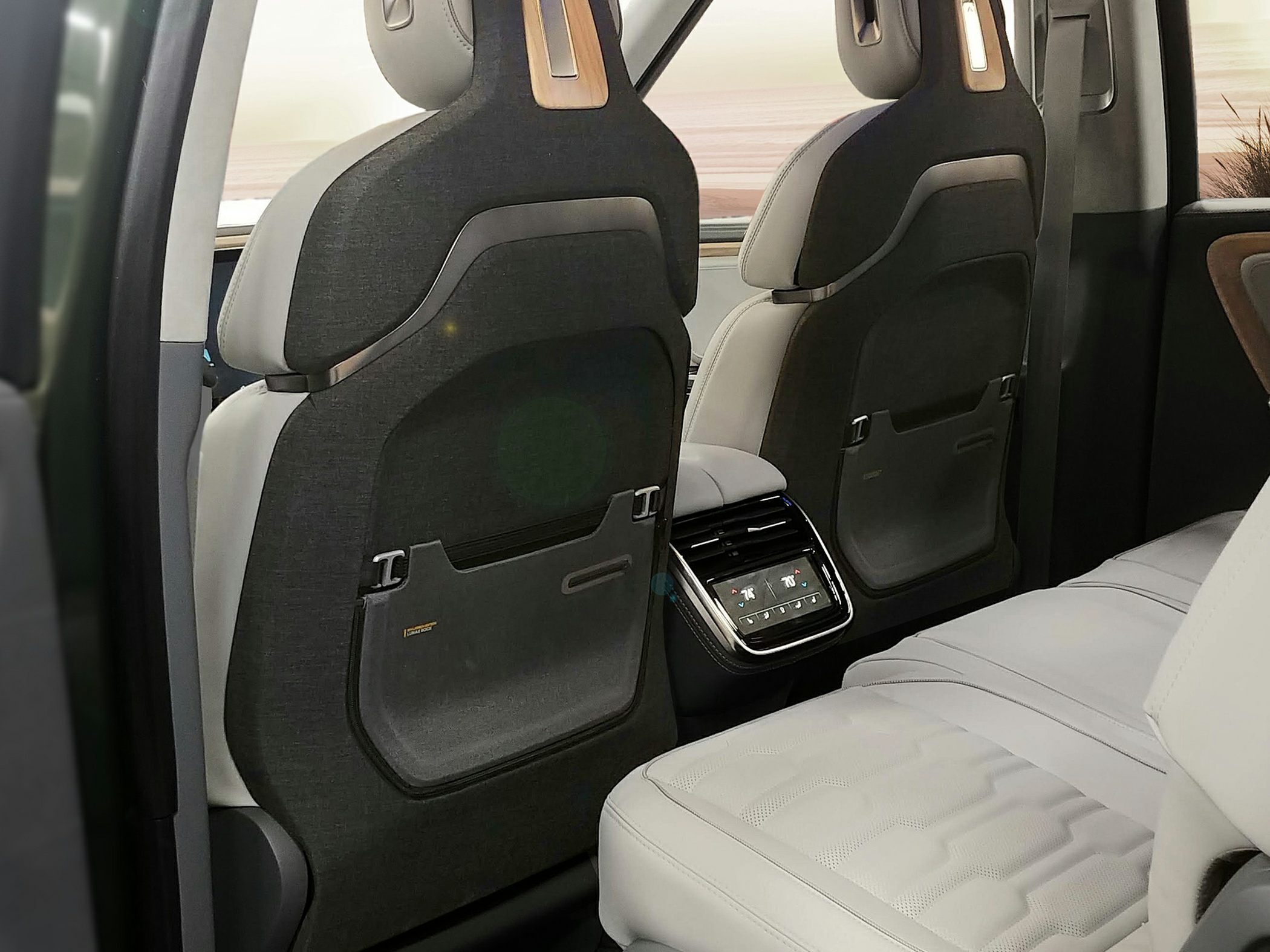 Rear seat climate control panel and seat backs with storage pockets