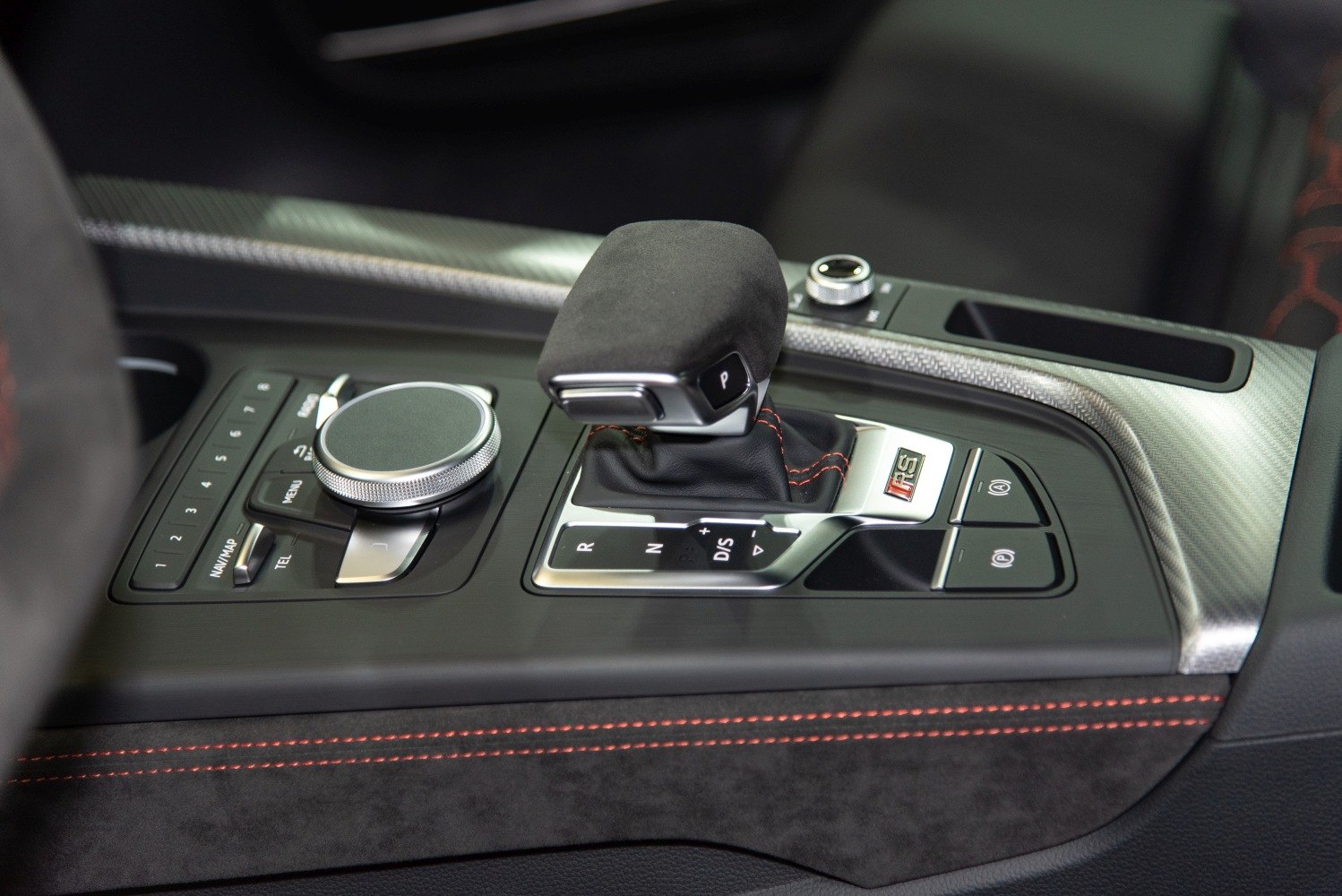 Gear shifter and multimedia control console with carbon fiber trim and red stitching
