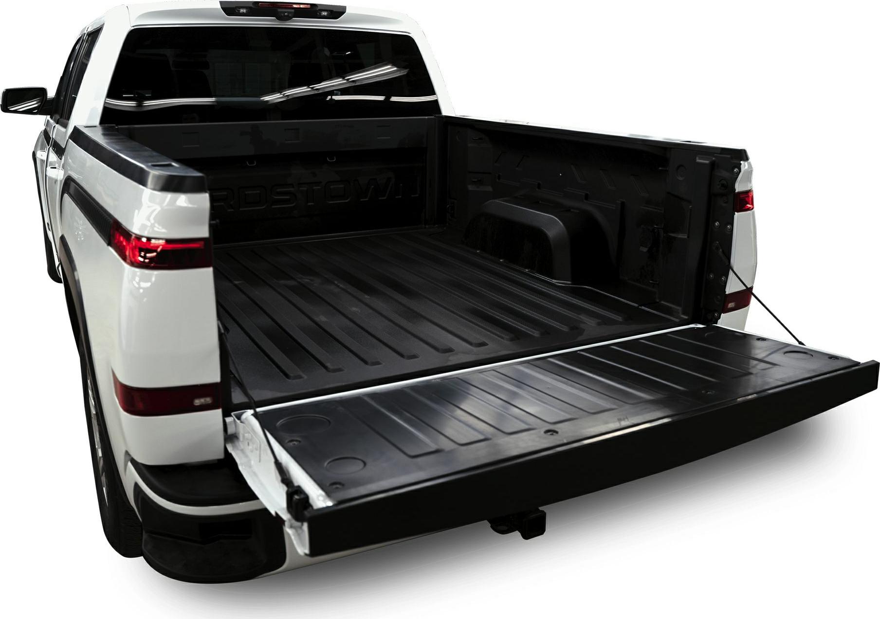 Open electric pickup truck bed with extended tailgate.