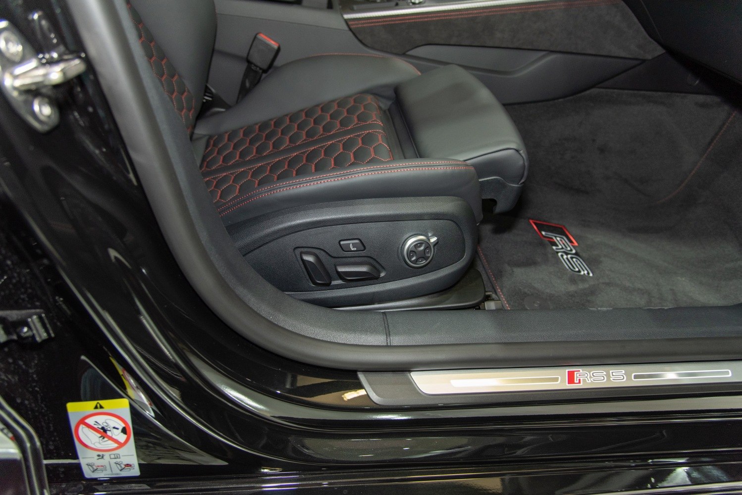 Leather seat with red stitching and electric adjustment controls next to RS 5 door sill