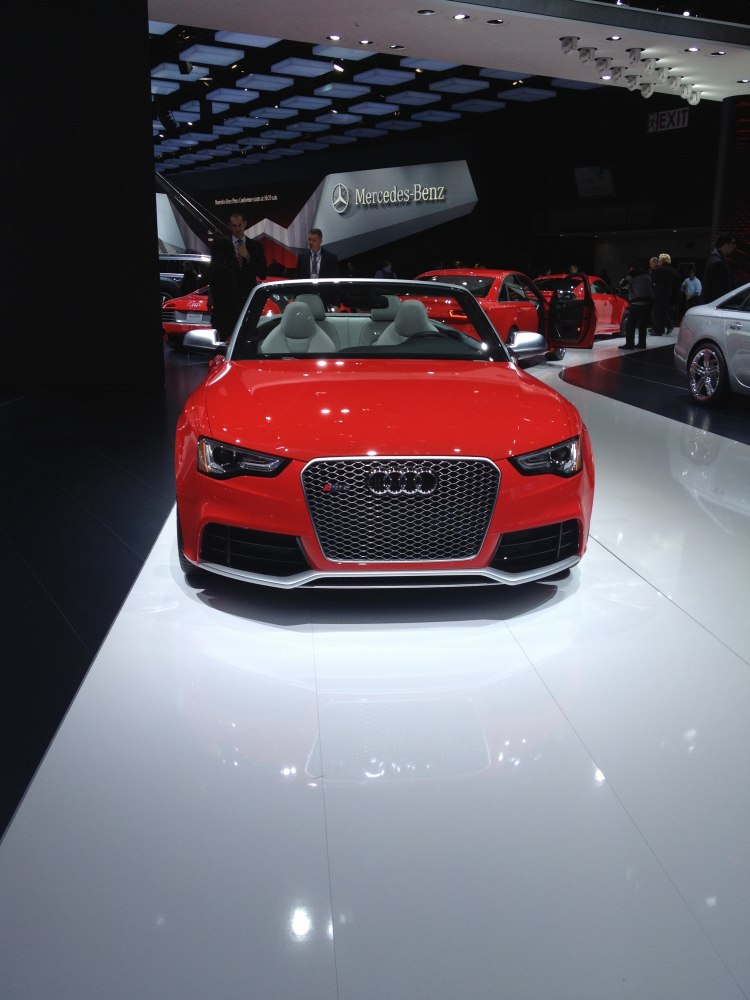 Front view of red convertible with distinctive grille and open roof