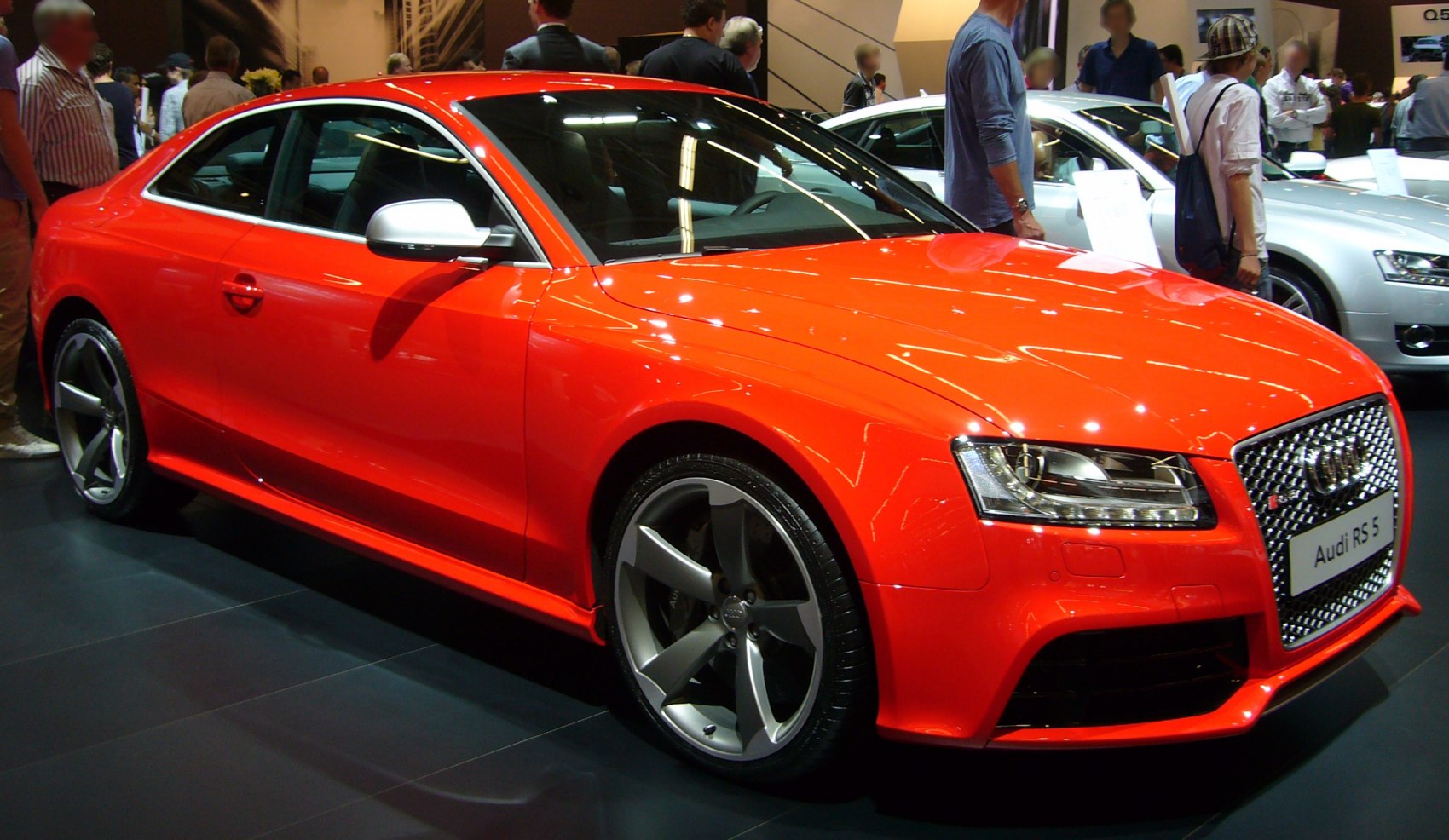 Red coupe with five-spoke alloy wheels and aggressive front design