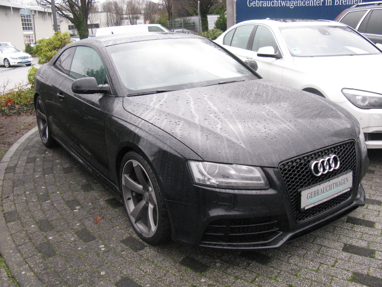 Front and side view of a sporty coupe with honeycomb grille and alloy wheels