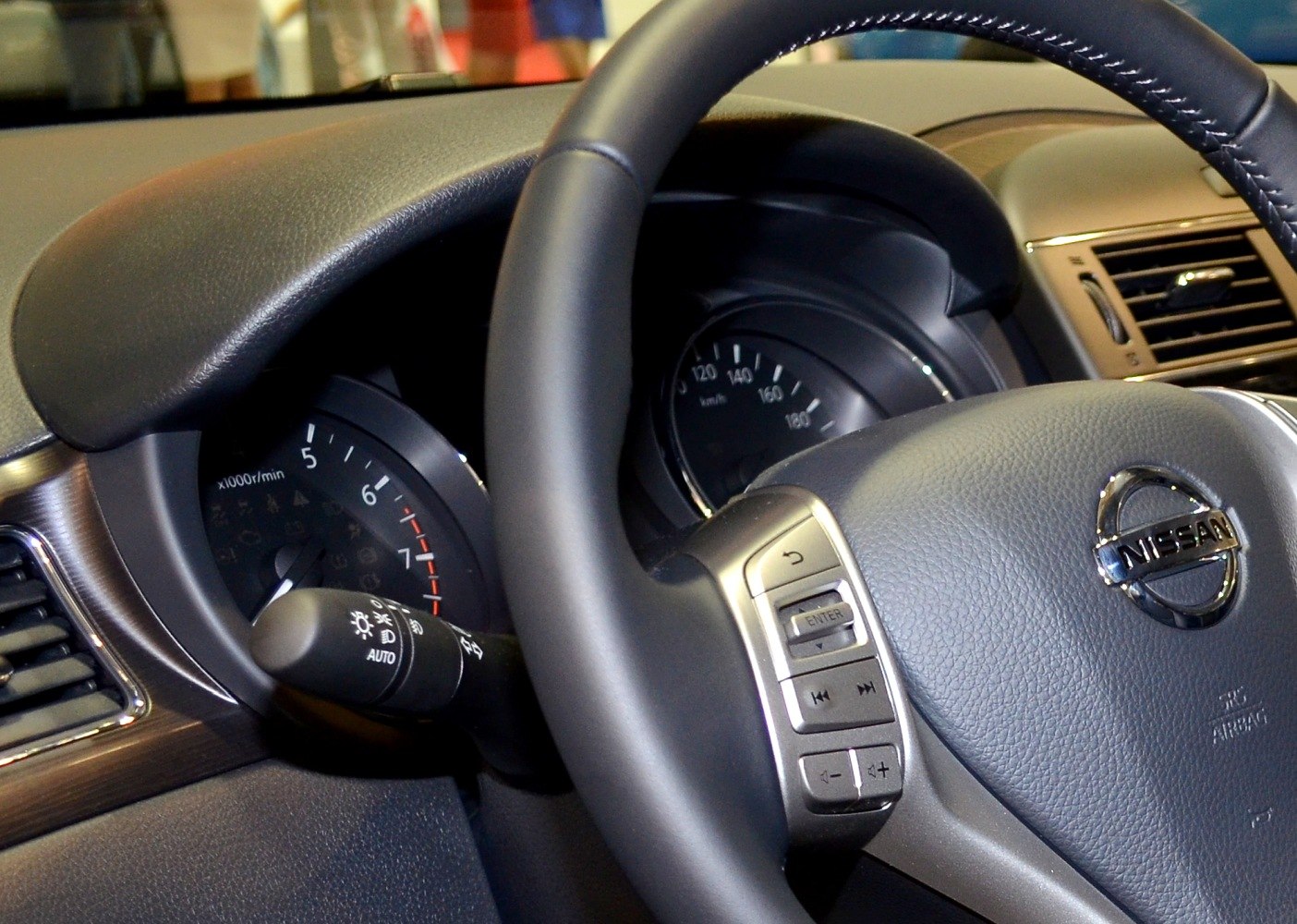 Steering wheel with control buttons and instrument cluster with speedometer and tachometer