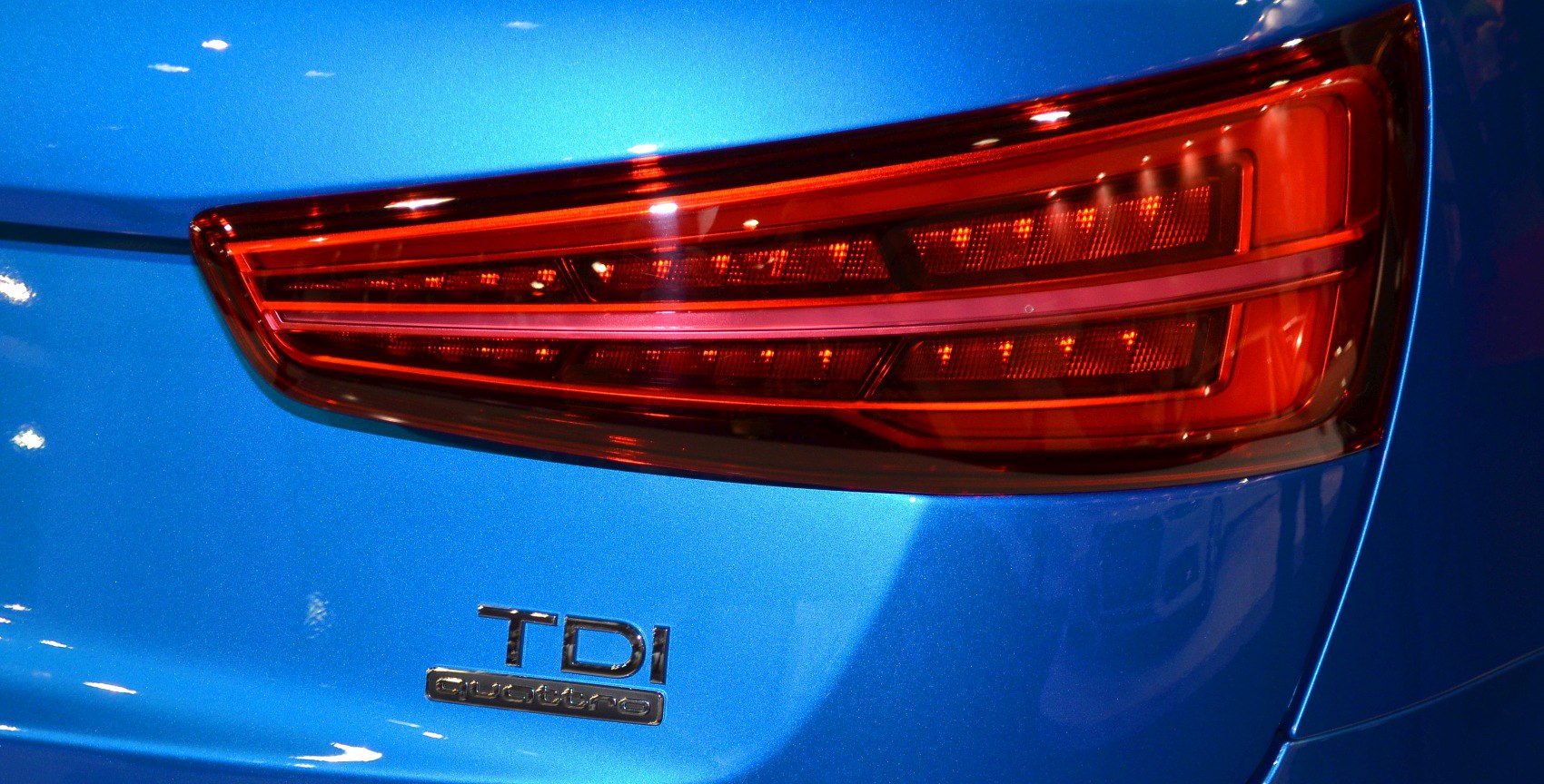 Rear LED taillight and TDI Quattro badge on a blue vehicle