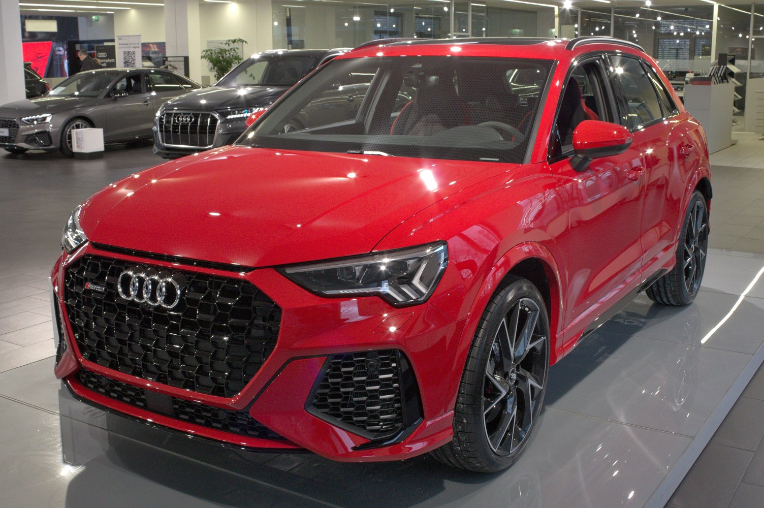 Red SUV with black honeycomb grille and sporty sporty design
