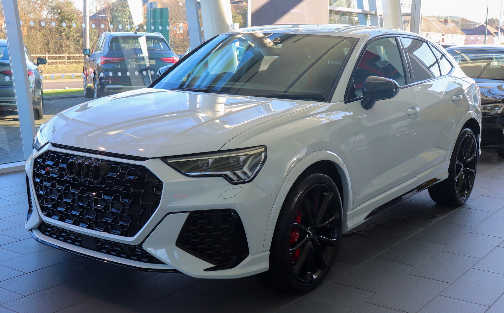 Aggressive front grille and black alloy wheels with red brake calipers