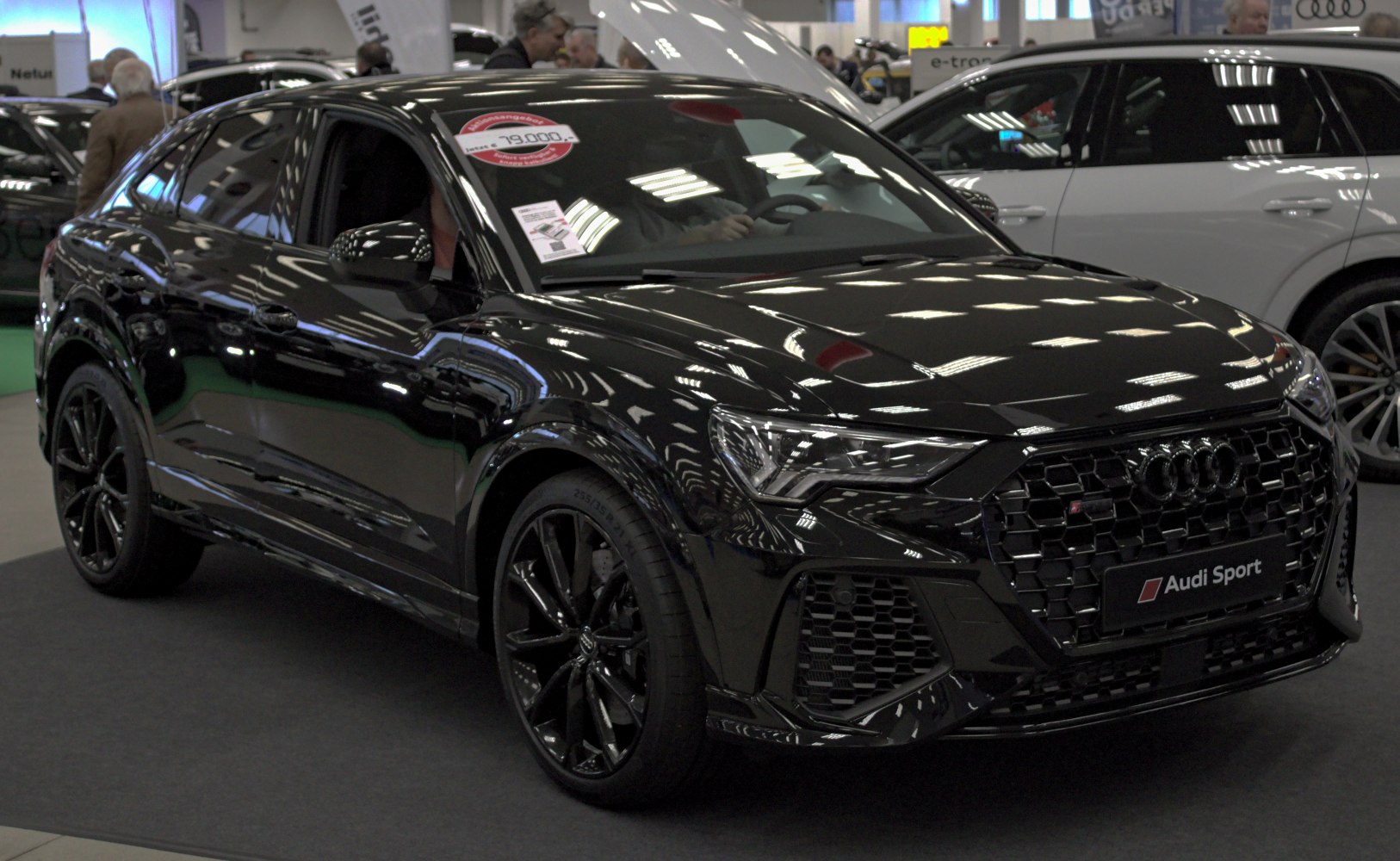 Front angled view of black SUV with aggressive grille and sleek headlights