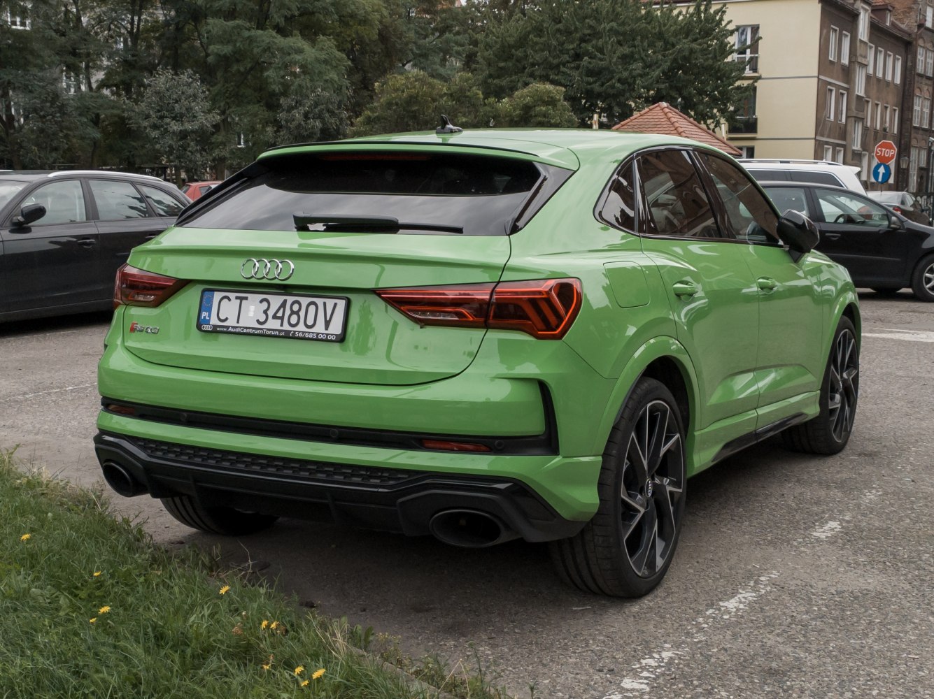 Rear and side profile of a green sporty compact SUV.
