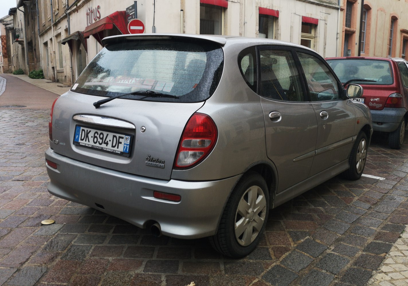 Rear and side view of compact hatchback with rounded tail lights and rear spoiler