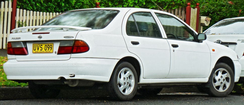White four-door sedan with rear spoiler and alloy wheels.