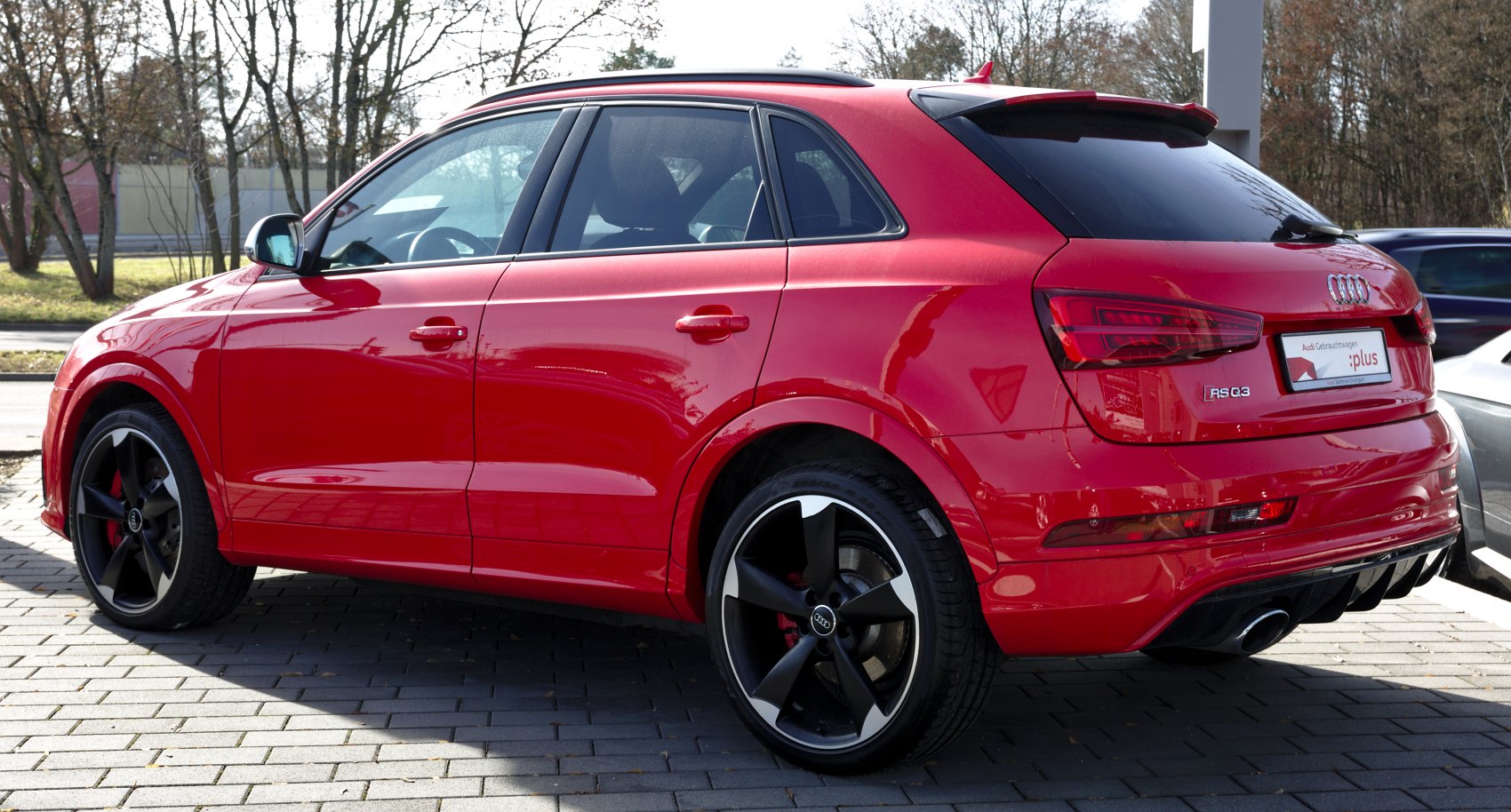 Red SUV rear and side profile with sporty wheels and tinted windows