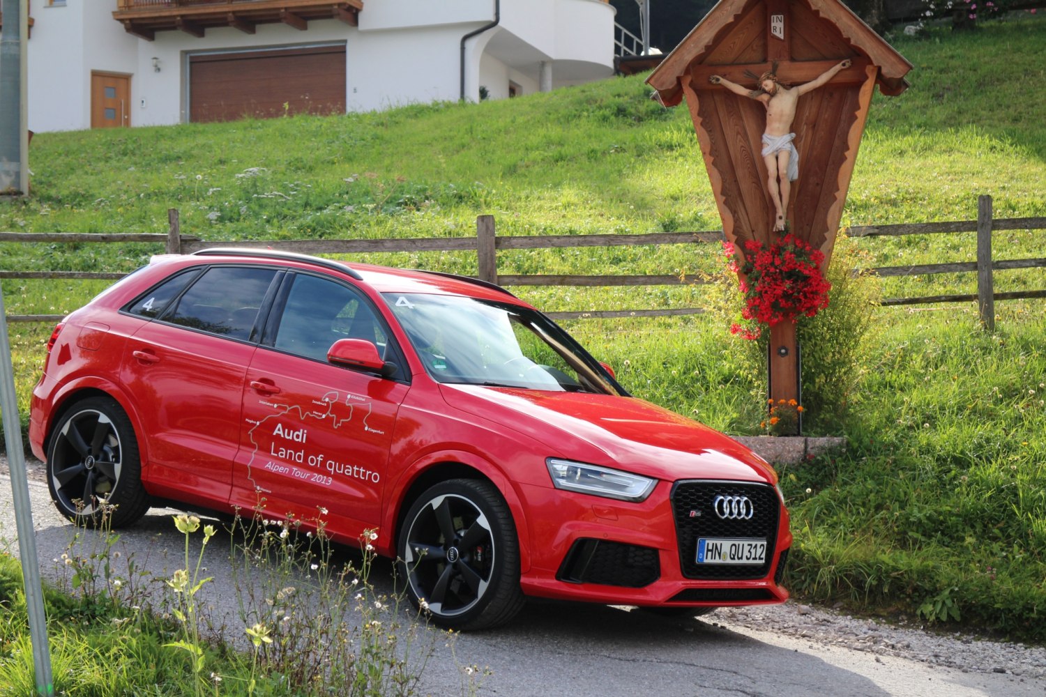 Red hatchback with black wheels and LED headlights