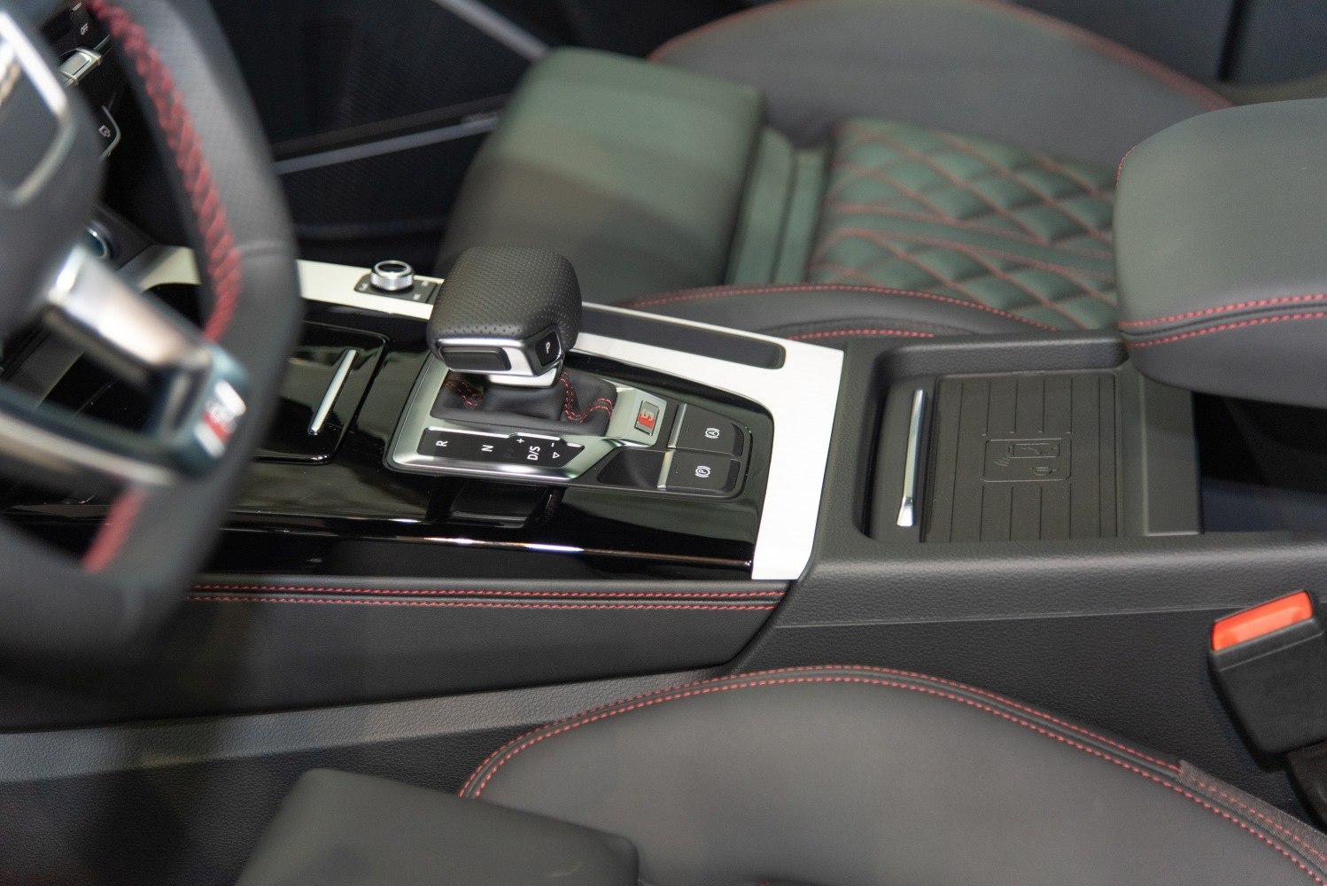 Close-up of gear shift and detailed red stitching on black leather interior