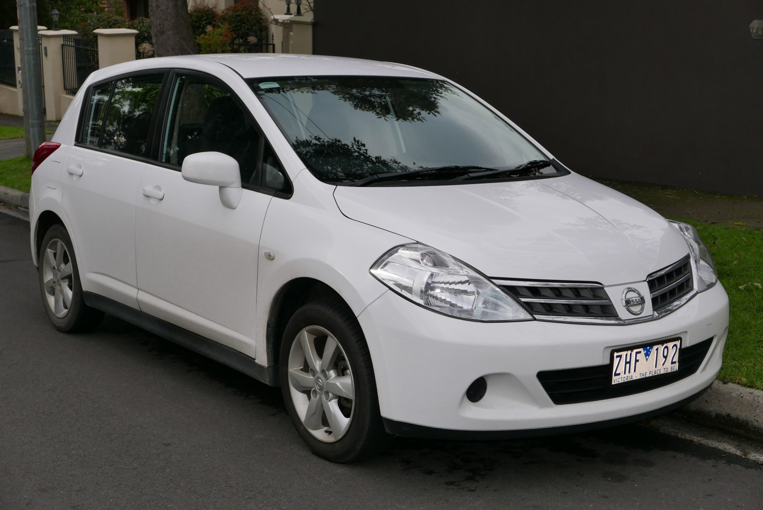 White 5-door hatchback showing front side view with distinctive headlights and grille