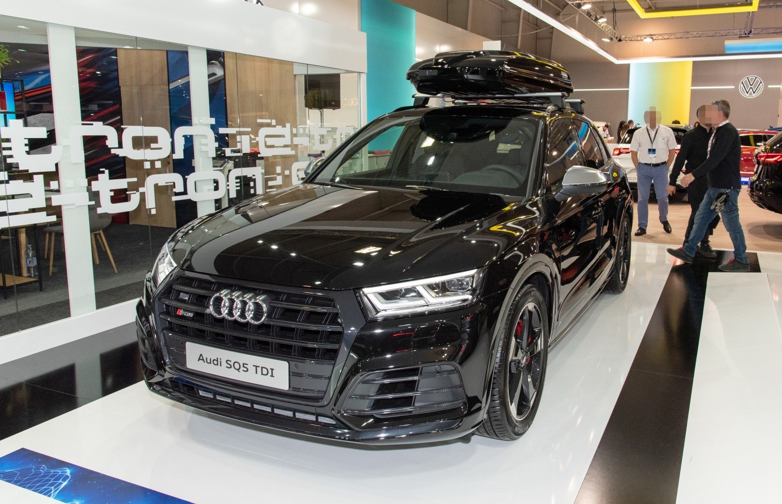 Black SUV with roof cargo box, sporty wheels, and modern LED headlights