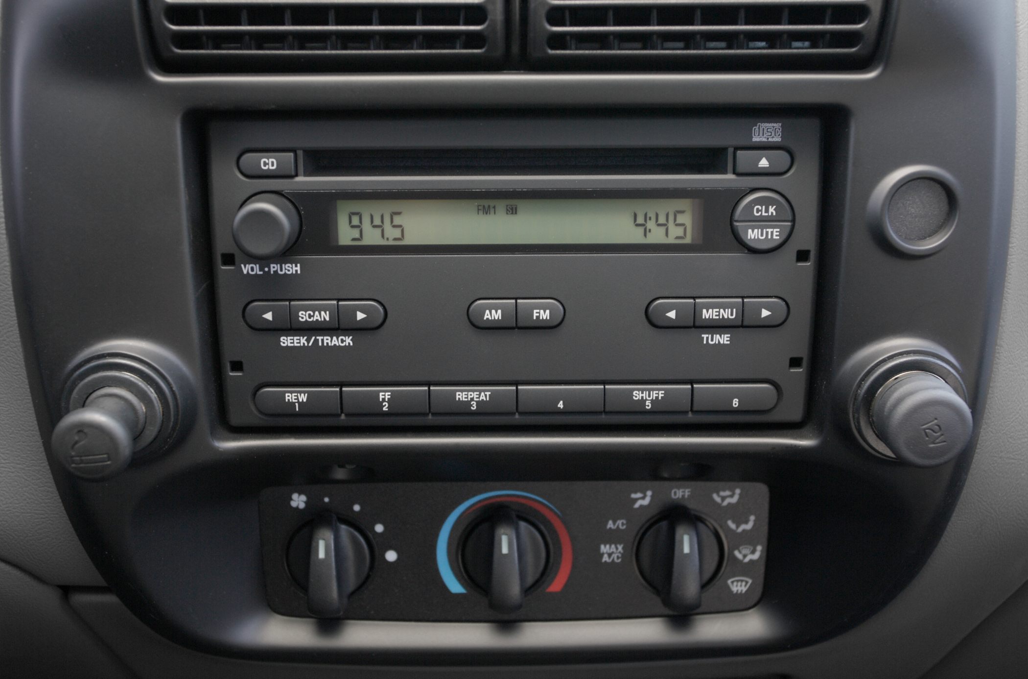 Close-up of car radio and manual climate control knobs