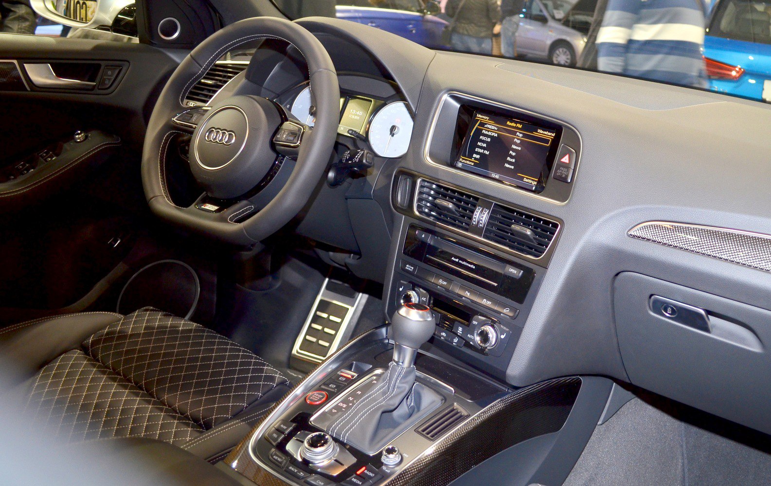 Dashboard, steering wheel, gear shift, and multimedia controls of a car interior