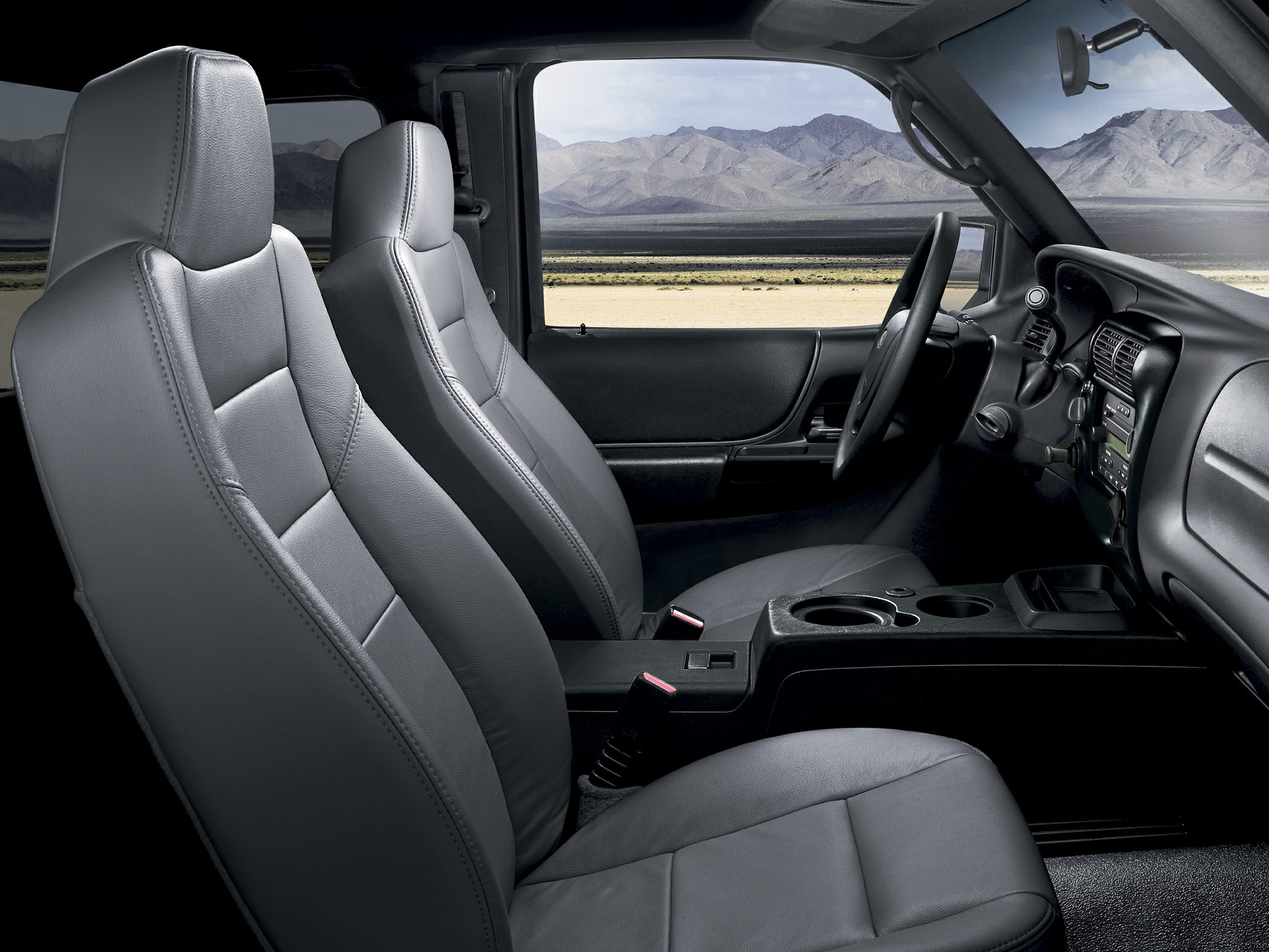 Gray leather seats and dashboard with center console and cup holders.
