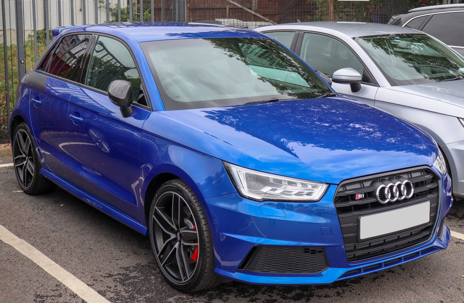 Front angle view of sporty blue hatchback with distinct headlights and alloy wheels.