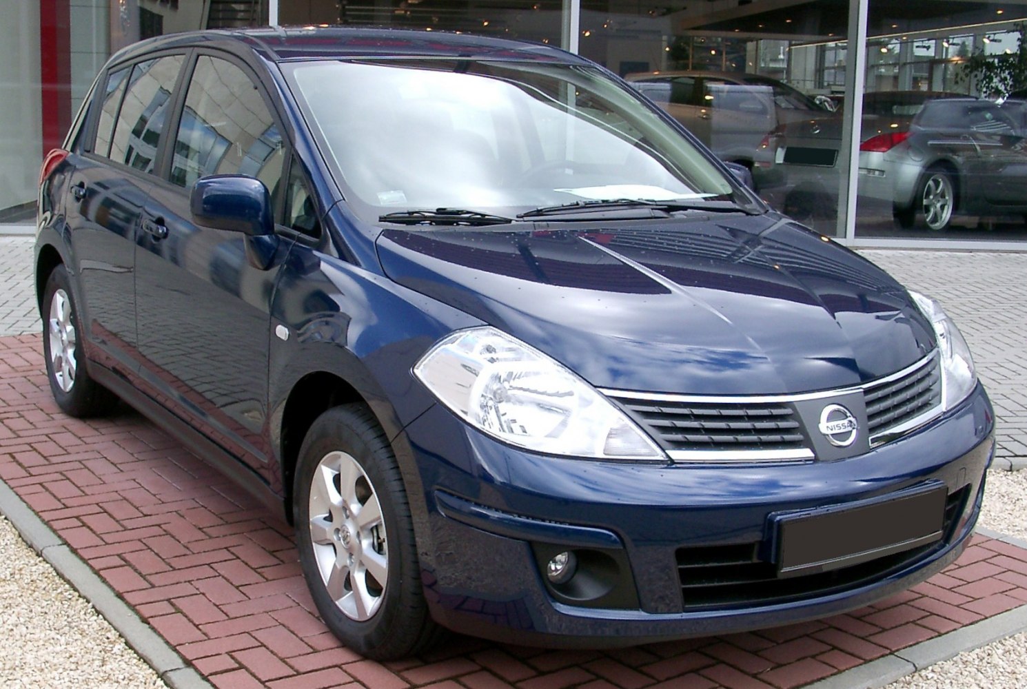 Front and side view of blue hatchback with distinctive headlights and grille