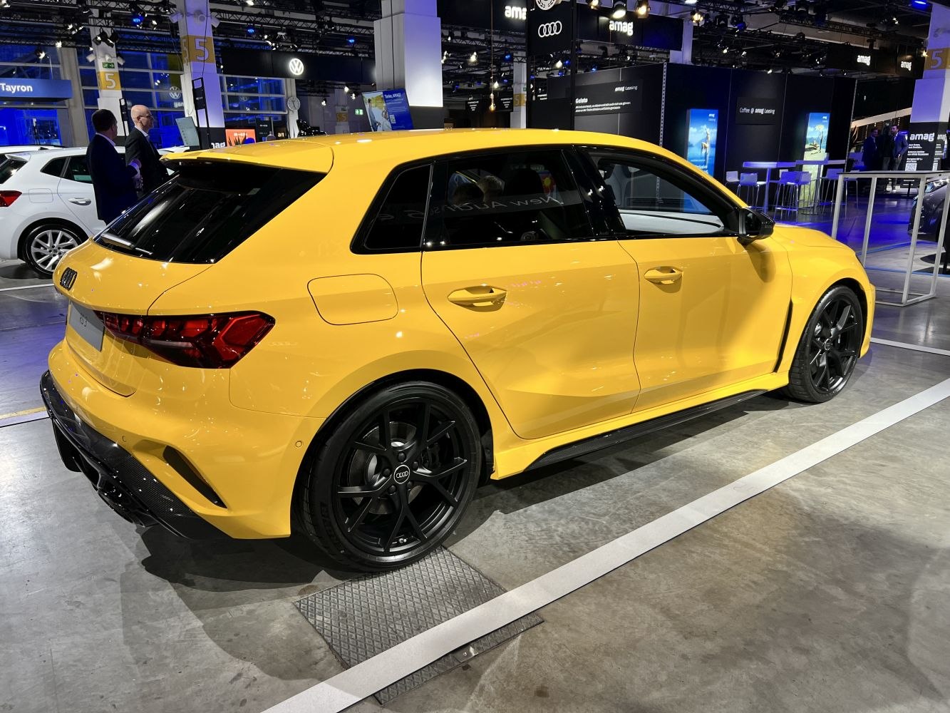 High-performance yellow sportback with black wheels and dynamic rear 3/4 perspective