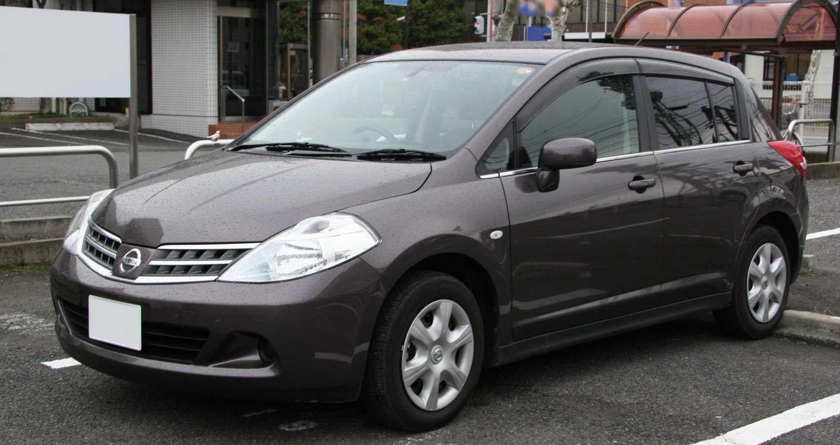 Front side view of a compact hatchback with rain droplets
