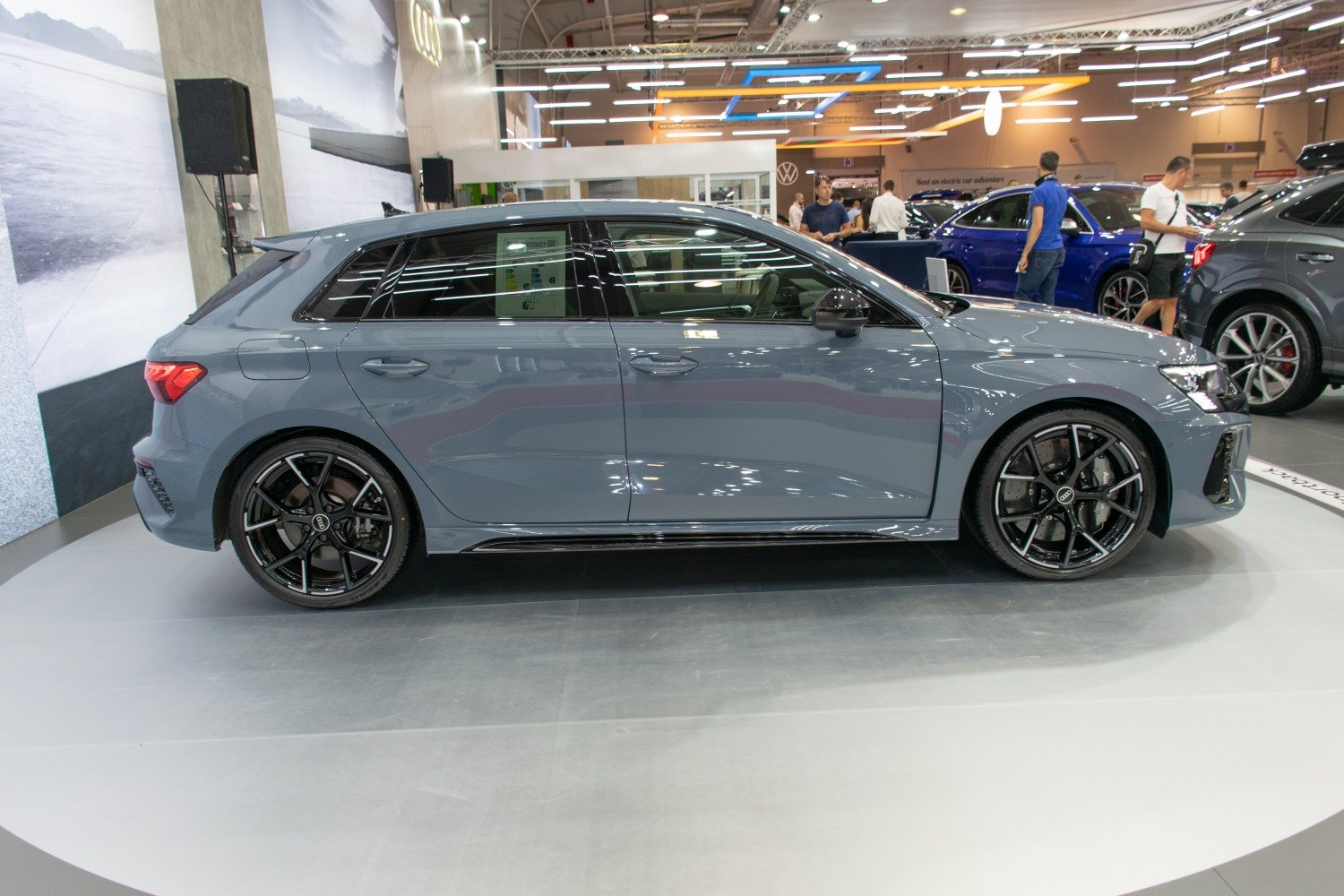 Sleek hatchback side profile with black multi-spoke alloy wheels