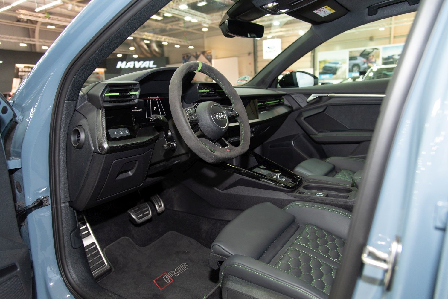 Sporty steering wheel and hexagonal pattern seats with green stitching