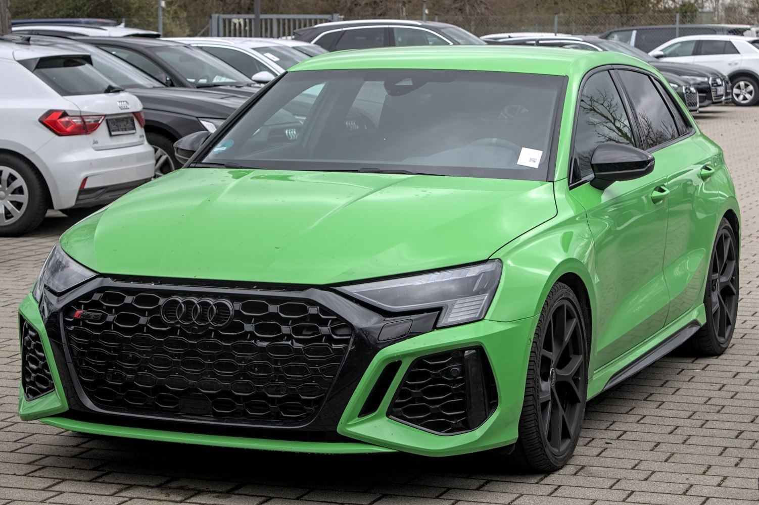 Aggressive front fascia with black honeycomb grille and matte black wheels