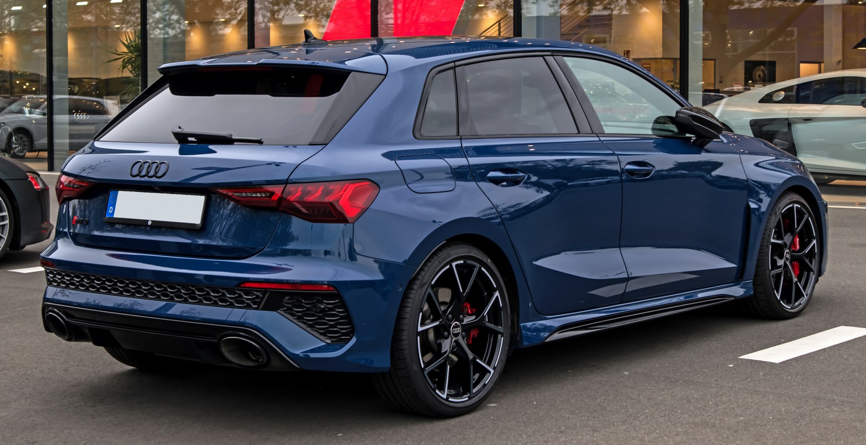 Rear view of sporty hatchback with black alloy wheels and dual exhaust