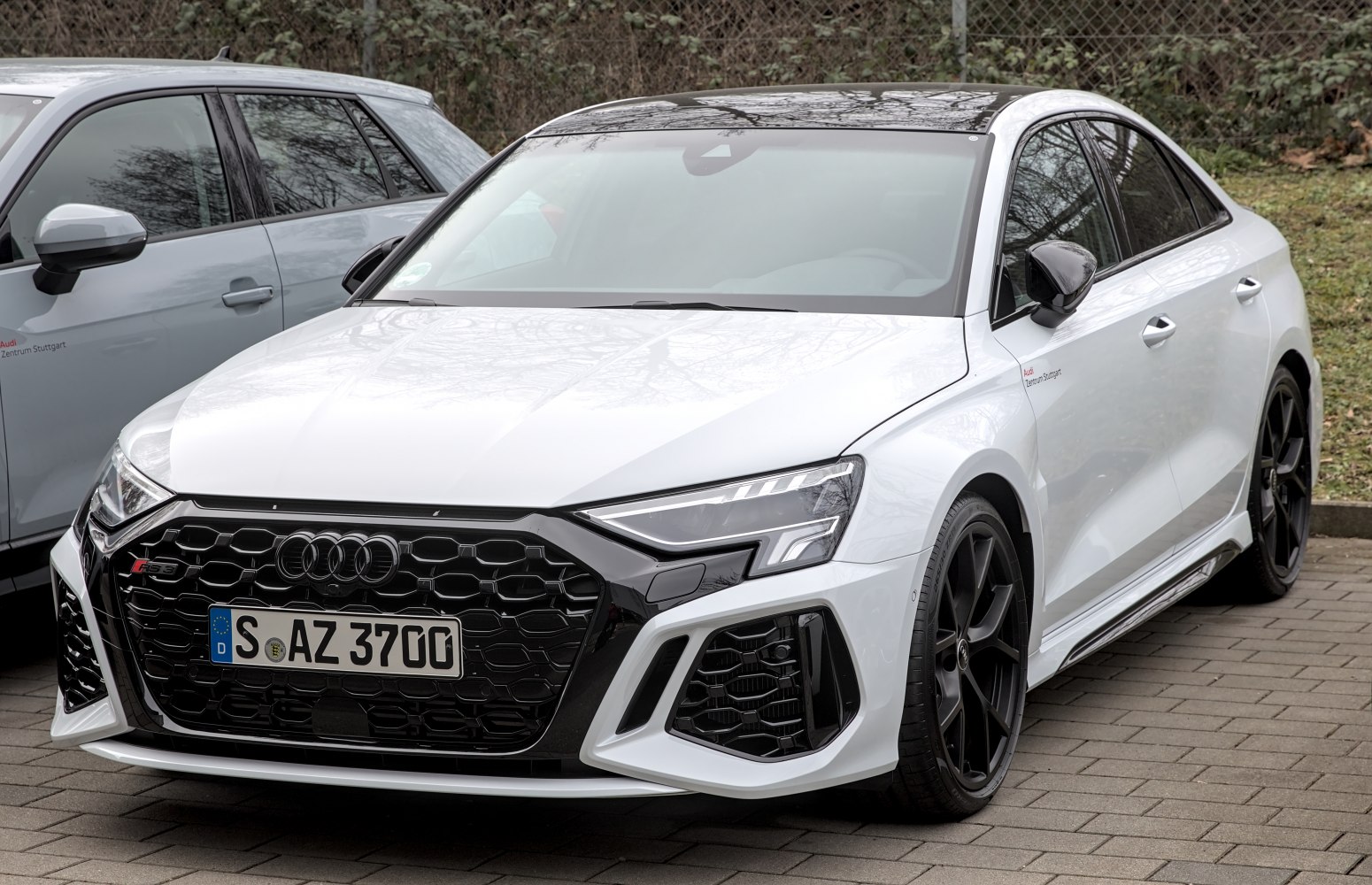 Front view with honeycomb grille, LED headlights, aggressive intakes, and alloy wheels
