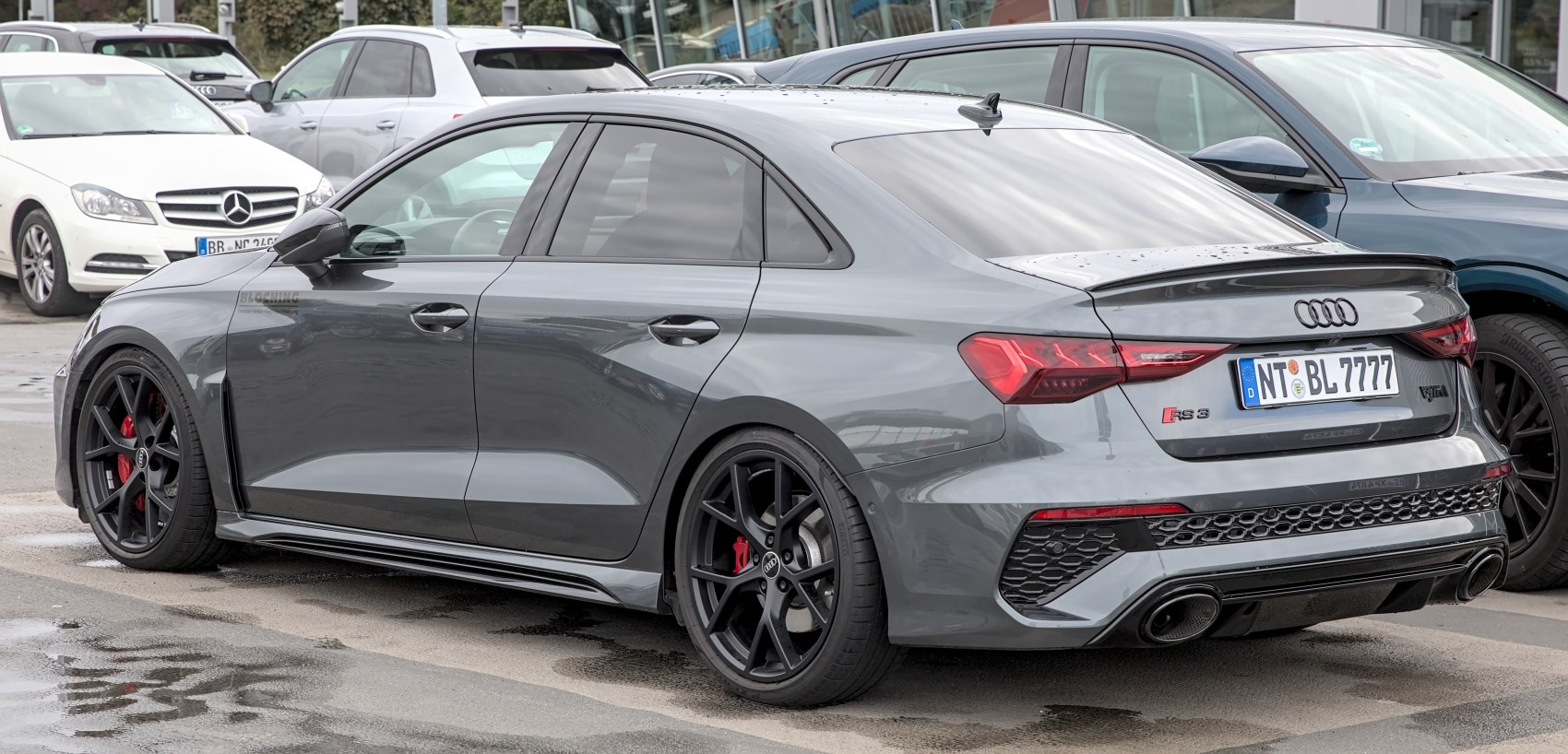 Rear side view with black multi-spoke wheels and sporty diffuser