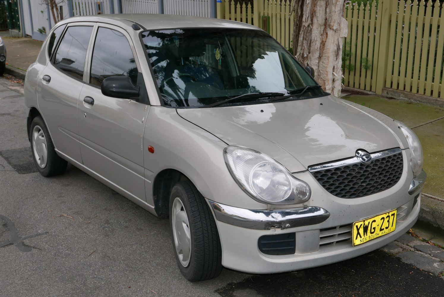 Front-side view of compact hatchback with distinctive headlight and grille