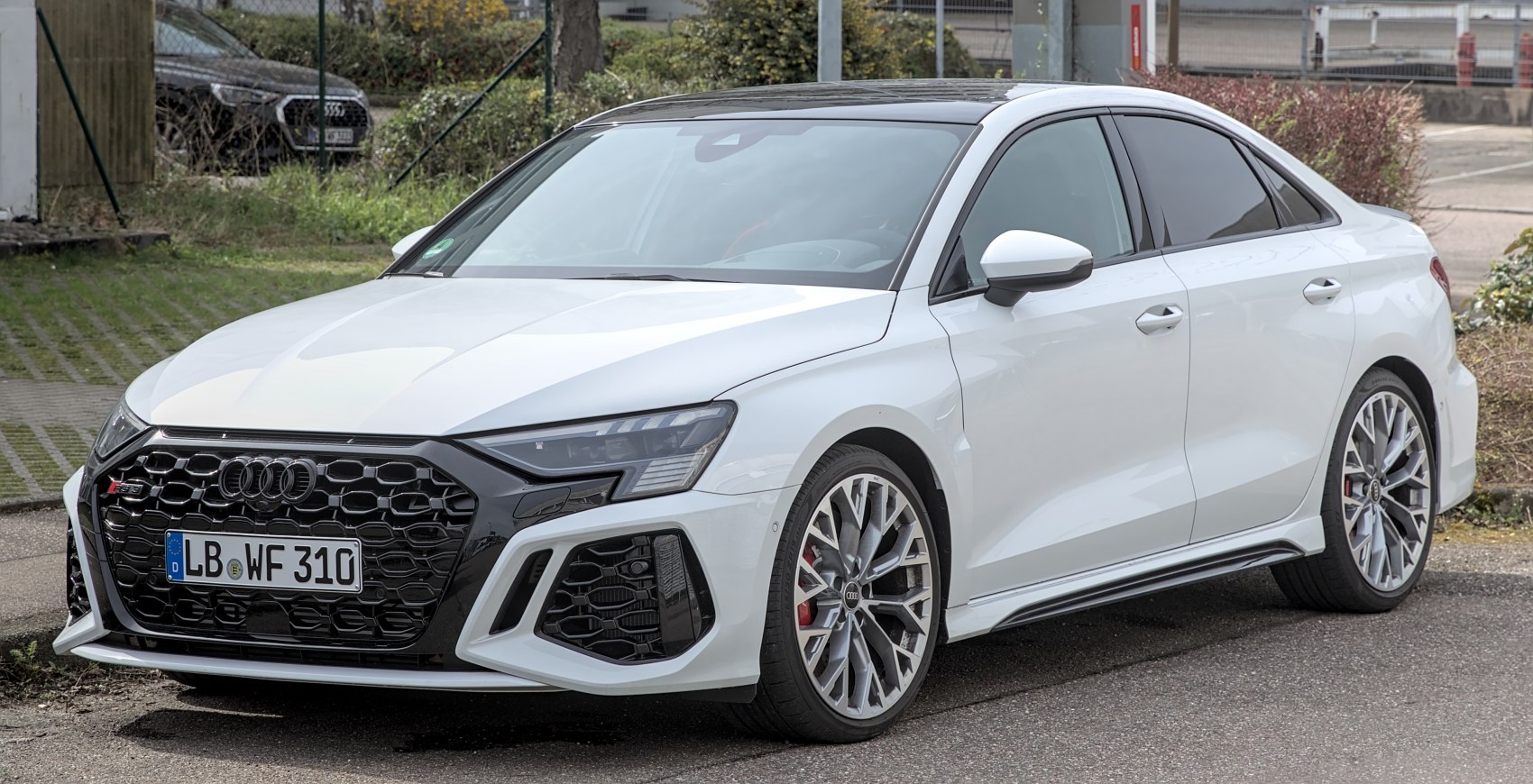 Front and side view of a sedan with honeycomb grille and multi-spoke alloy wheels