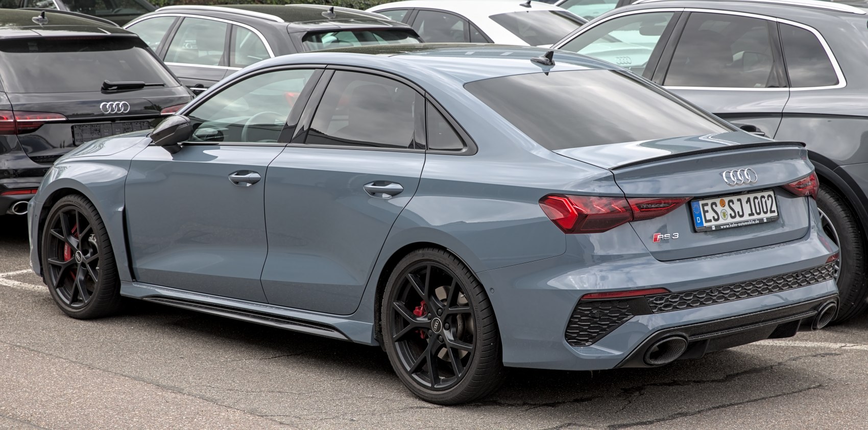 Rear side profile with black alloy wheels and dual exhausts