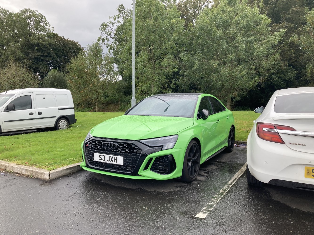 Green sports sedan with black honeycomb grille and sleek headlights