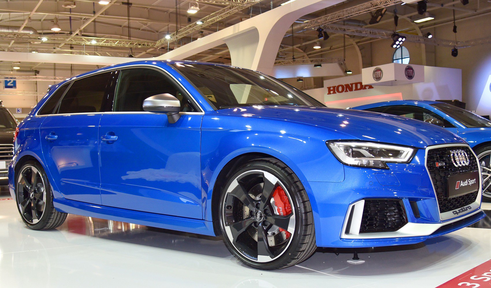 Blue hatchback with red calipers and alloy wheels front-side view