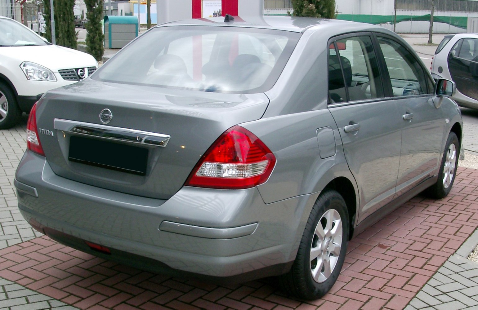 Silver four-door sedan rear with distinctive taillights and chrome trim