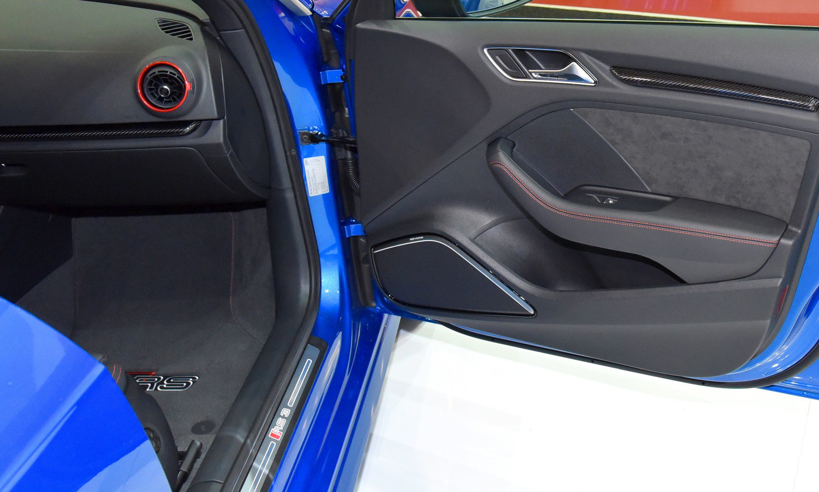 Interior door panel with black upholstery and red accent, RS sportback floor mat.