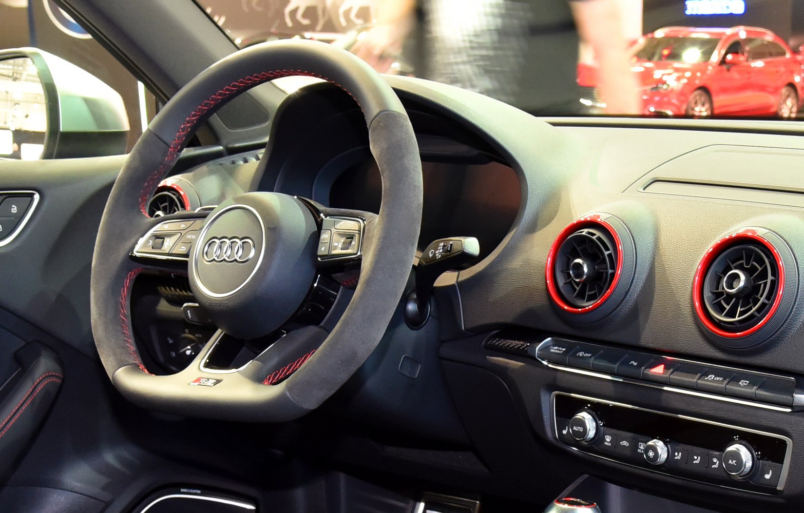 Sporty steering wheel with red stitching and red-accented dashboard air vents