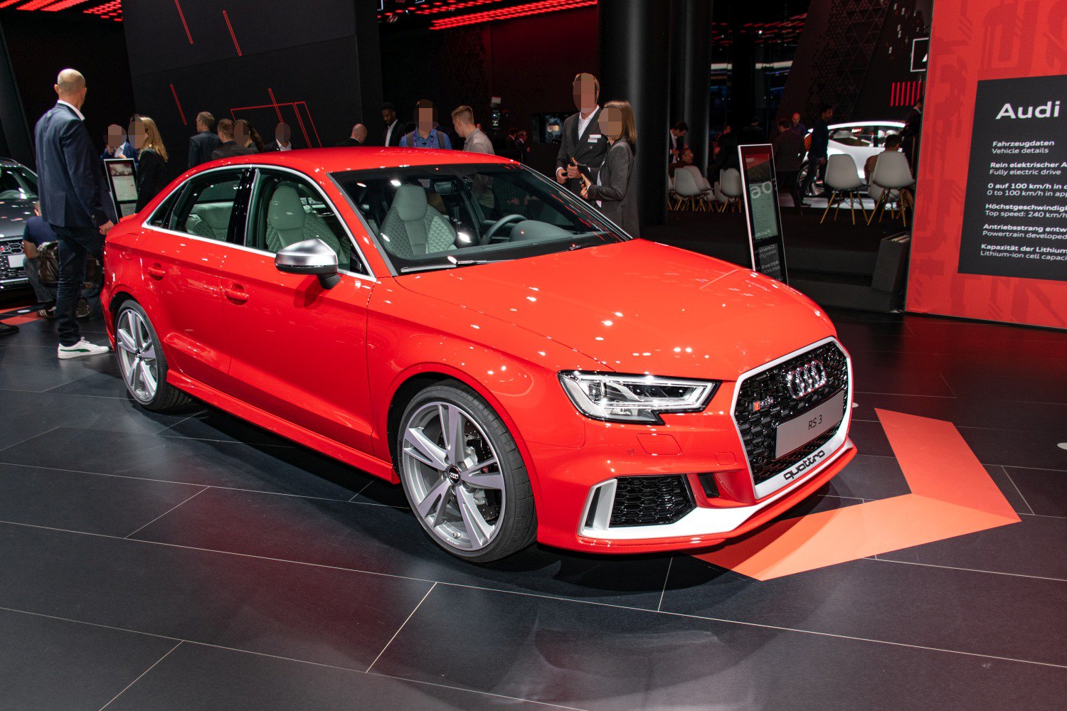 Red sporty sedan front side view with distinctive grille and alloy wheels