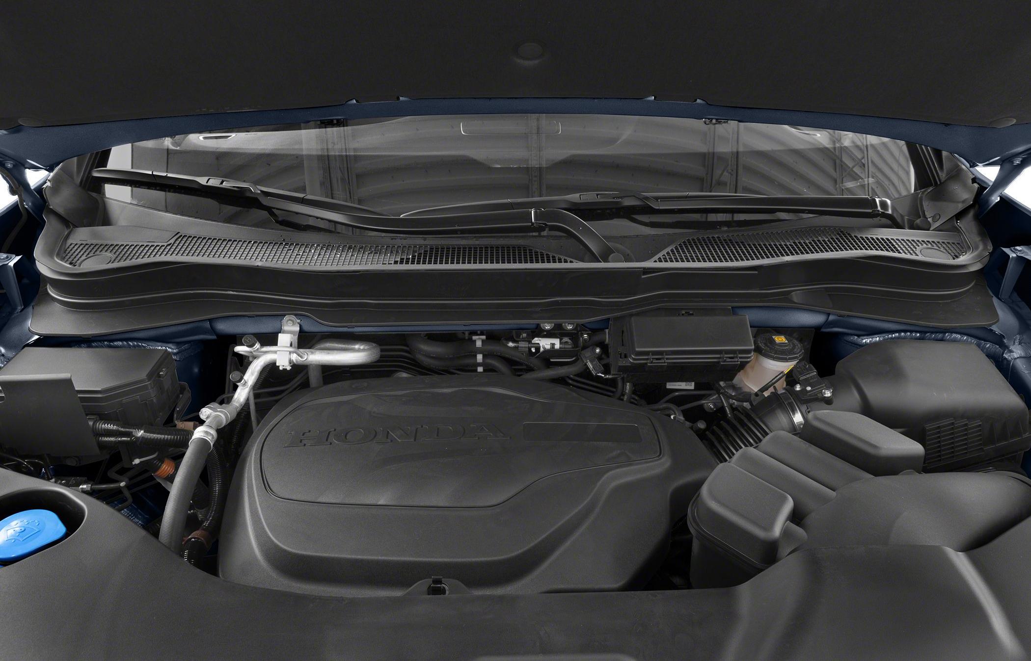 Modern engine compartment with Honda embossed cover and component layout.