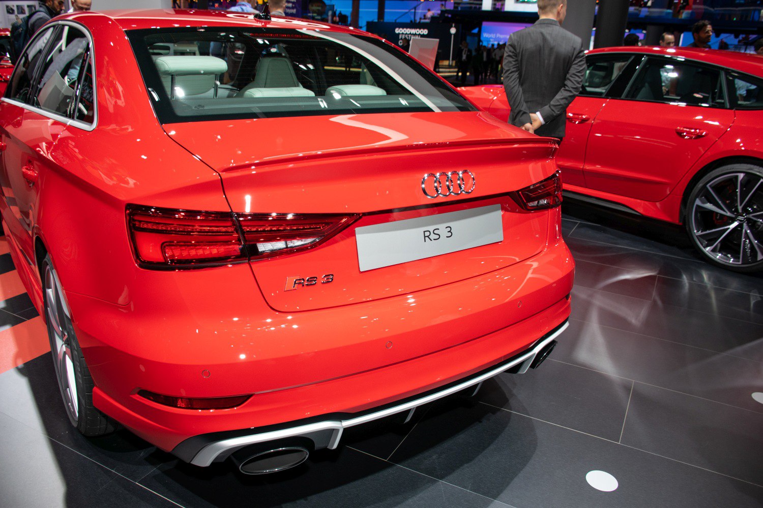 Red sedan rear with distinct tail lights and quad exhausts