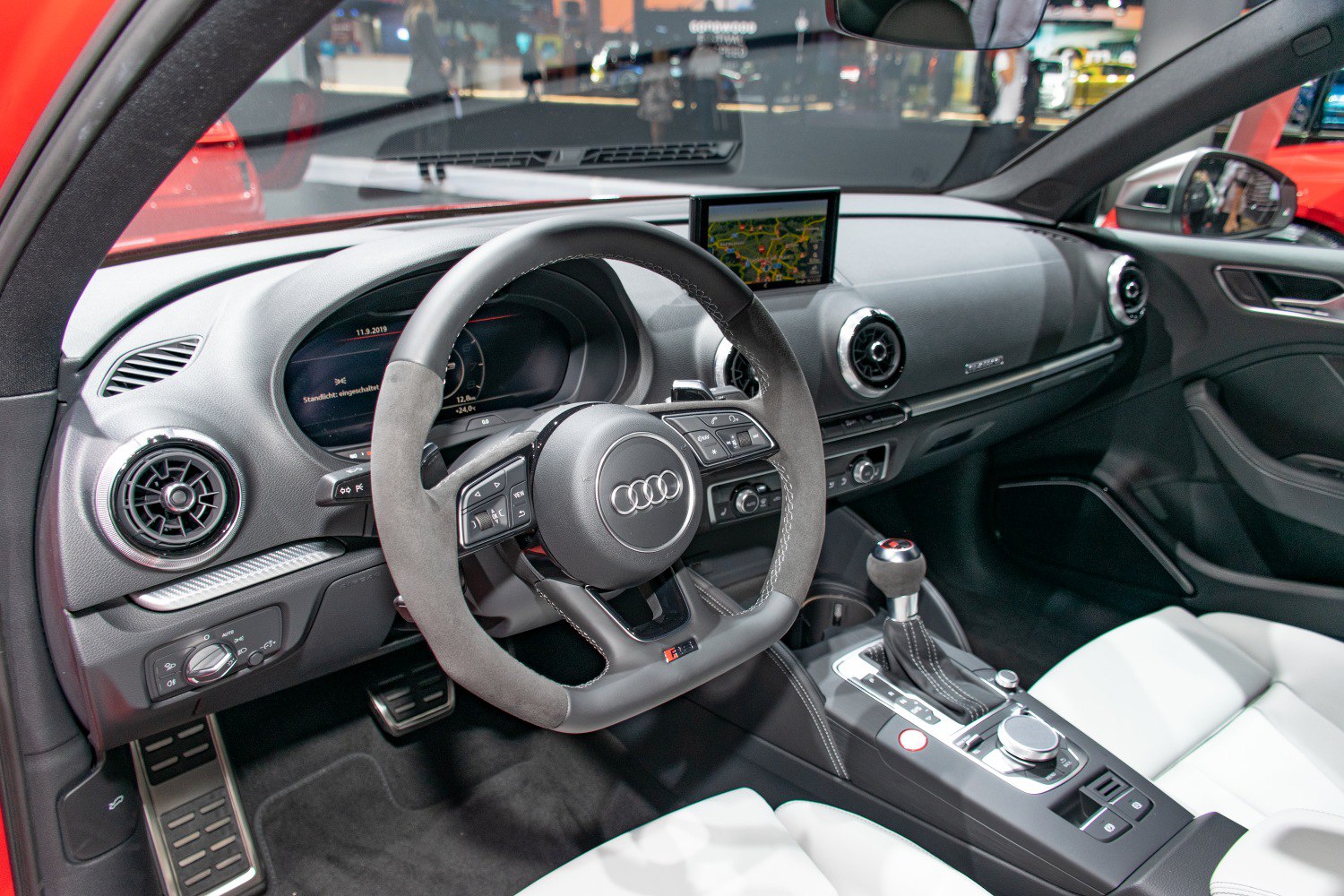 Sport steering wheel and digital dashboard in luxury car interior.