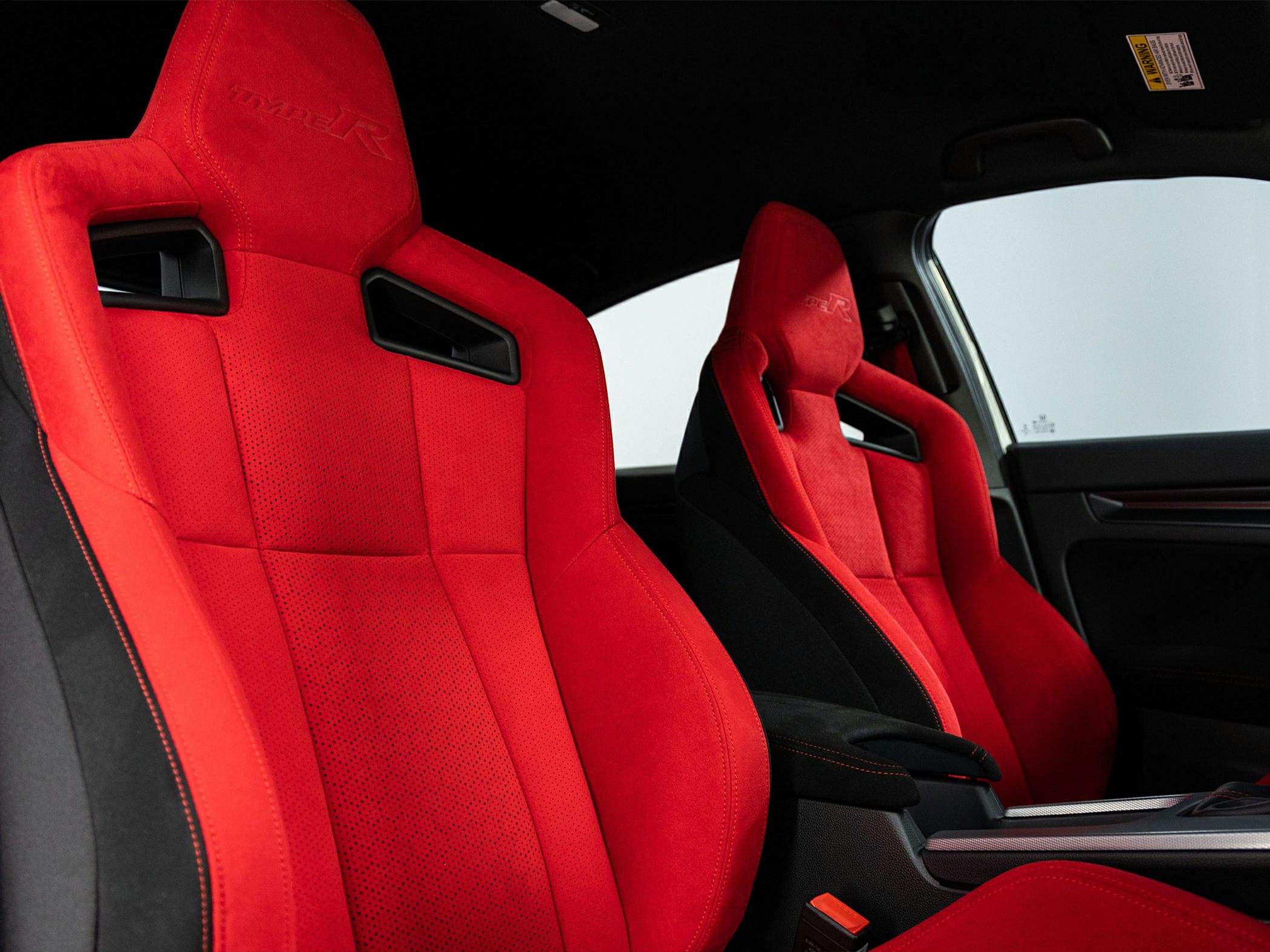 Red racing bucket seats with sporty design inside a performance car