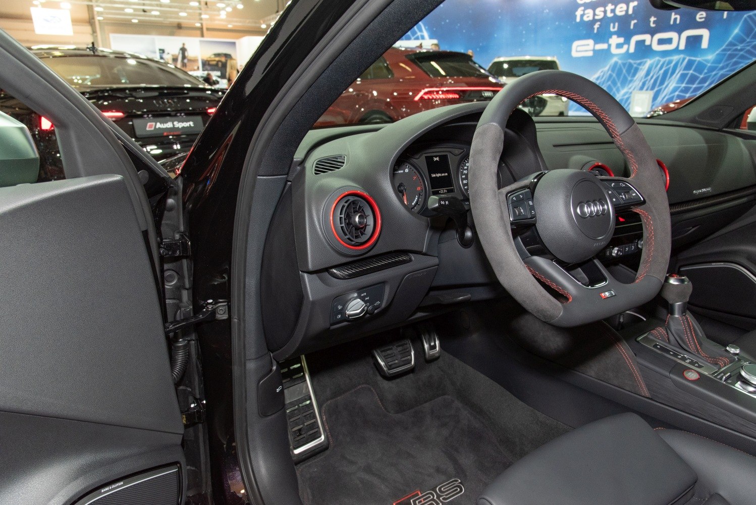 Sporty steering wheel and interior dashboard with red accents and pedals