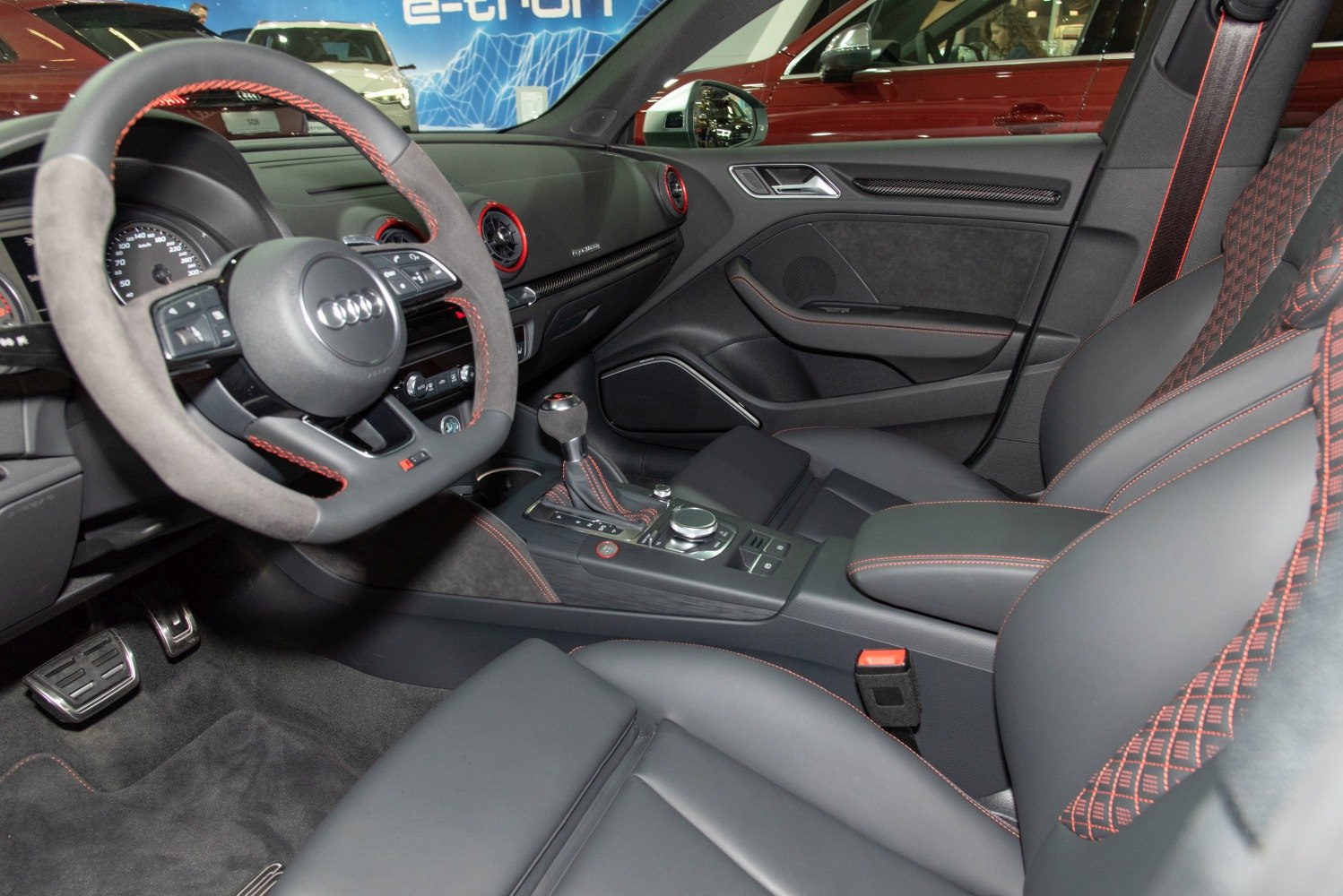 Sporty steering wheel and red-stitched seats with carbon fiber trim.