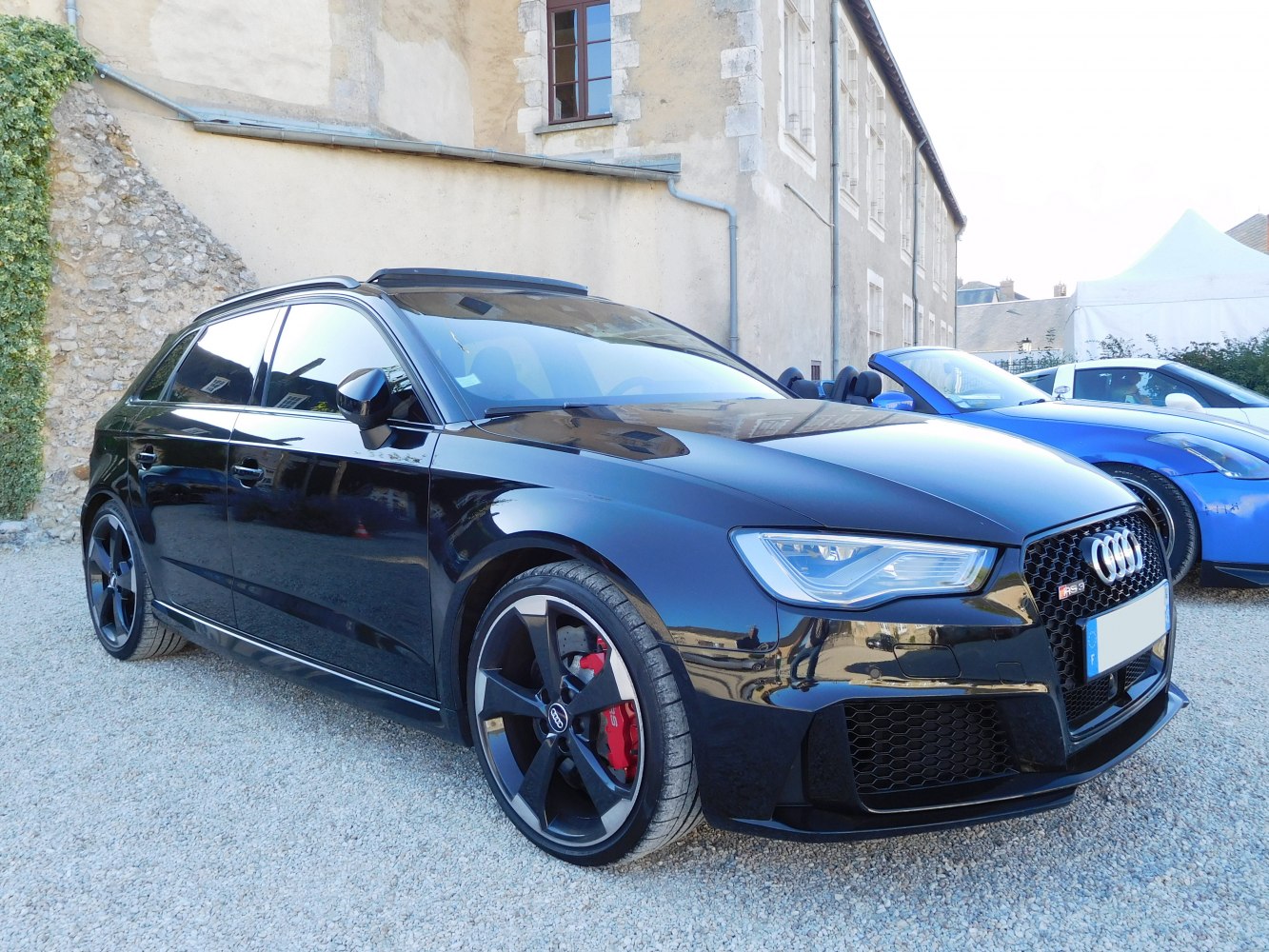 Sporty hatchback with honeycomb grille, large alloy wheels, and red brake calipers