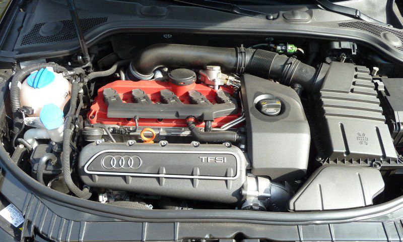 Audi RS 3 Sportback TFSI engine bay with red valve cover and intake components